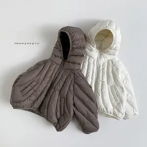 Detail of kids lightweight hooded down jackets with curved quilting in brown and white