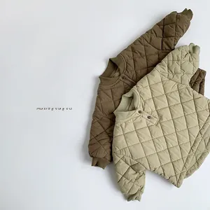 Detail of children quilted cotton jackets featuring diamond patterns and ribbed cuffs
