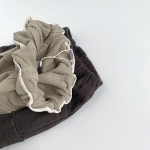 Détail du pantalon d'hiver en polaire montrant le tissu sergé et la taille élastique