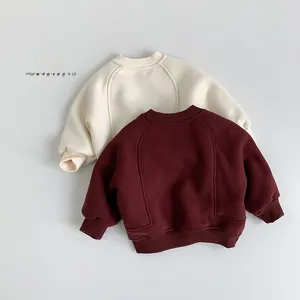 Detail of fleece-lined sweatshirts for kids in off-white and burgundy with ribbed cuffs