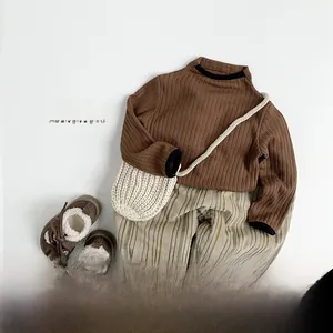 Flat lay of kids thermal knit outfit with brown top and cream striped joggers