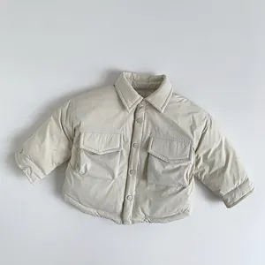 Dettaglio della giacca in piumino per bambini beige con tasche a patta e bottoni