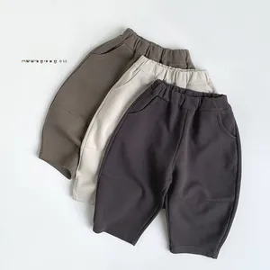 Flat lay of knit kids' sweatpants in army green, off-white, and dark gray with elastic waist