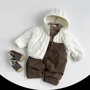Kids quilted white down jacket with brown sweater and cargo pants flat lay set