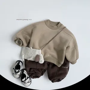 Flat lay of warm fleece-lined khaki sweatshirt and brown joggers with a cute dog bag