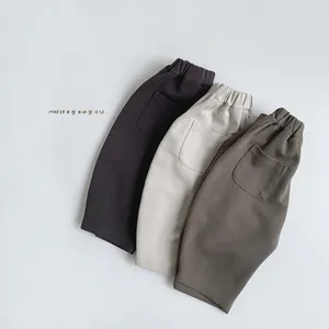 Detailed flat lay of children's knit trousers in grey, cream, and olive green colors