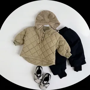 Flat lay of kids winter clothing set with khaki quilted jacket and knit beanie hat