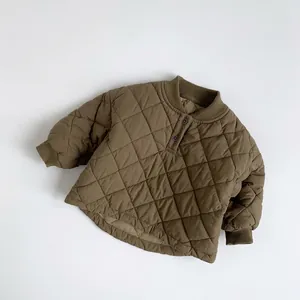 Detail of children's brown quilted thermal jacket with diamond pattern and ribbed cuffs