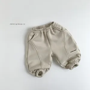 Detail of fleece-lined kids joggers in beige with Study Hard print and elastic waist