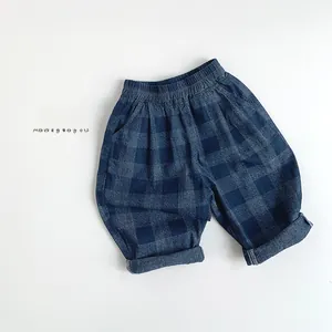 Détail d'un pantalon à carreaux bleu pour enfant avec taille élastique et revers