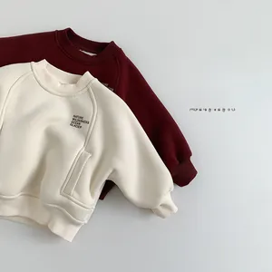 Flat lay of cream and red fleece-lined sweatshirts for kids with rib-knit cuffs and neck