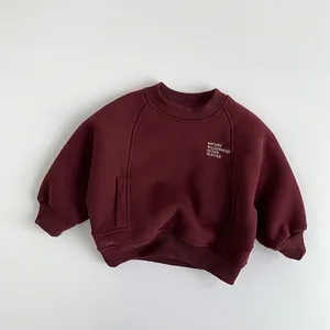 Detail of red fleece sweatshirt with white text print and decorative stitching lines