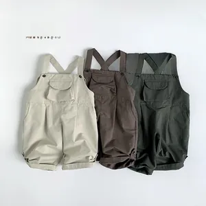 Detail of children's cotton overalls in beige, dark coffee, and forest green with pockets