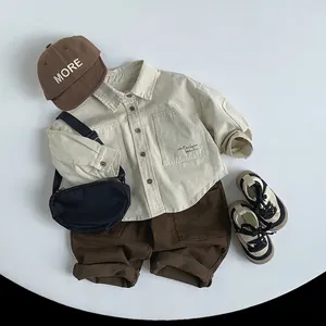 Classic earth-toned kids outfit with beige shirt, brown trousers, and stylish cap