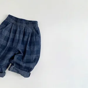 Détail du pantalon à carreaux enfant avec taille élastique et texture denim en coton