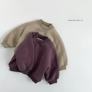 Close-up of beige and purple fleece sweatshirts featuring ribbed cuffs and crewneck details