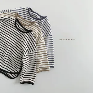 Détail de trois t-shirts à manches longues rayés en coton dans des tons terre neutres