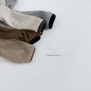 Close-up of ribbed knit cuffs in grey, khaki, and brown for children warmth