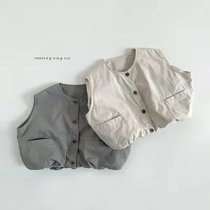 Detailed view of beige and dark grey cotton vests featuring front buttons and pockets