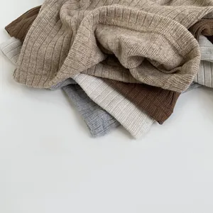 Close-up of ribbed knit fabric texture in khaki, brown, and grey colors for kids