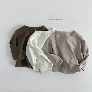 Close-up of three long-sleeve cotton t-shirts in coffee, beige, and taupe tones