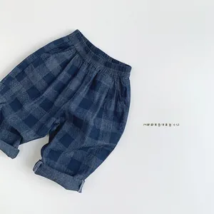 Détail du pantalon à carreaux bleus pour enfants avec taille élastique et poches latérales