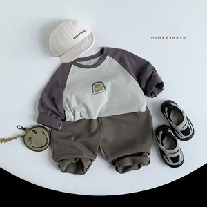 Flat lay of kids minimalist cotton long sleeve shirt and matching brown knit trousers set