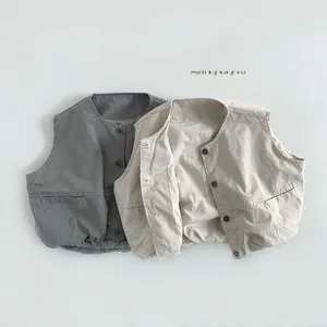 Detail of grey and beige cotton vests featuring natural texture and elastic hem design