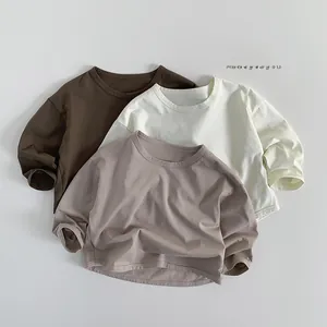 Flat lay of earth-toned long sleeve cotton T-shirts with ribbed cuffs and drop shoulder detail