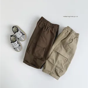 Détail de shorts cargo pour enfants marron et kaki avec taille élastique et poches latérales