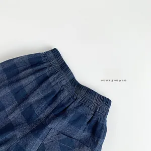 Détail de pantalon à carreaux bleu marine pour enfant avec taille élastique et tissu en coton