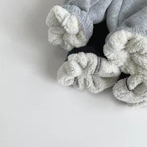 Close-up detail of grey kids sweatpants showing thick white sherpa fleece lining