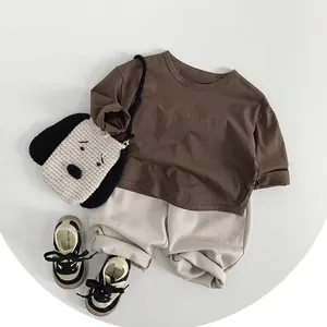 Kids minimalist casual outfit featuring dark brown sweatshirt and cream pants set