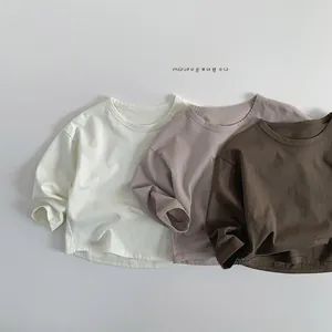 Close-up of cotton long sleeve kids t-shirts in beige, purple, and brown tones