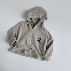 Detail view of khaki cotton hoodie for kids with lucky graphic and side slit hem