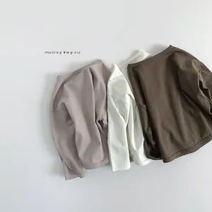 Flat lay of three basic long sleeve cotton t-shirts for kids in neutral autumn tones