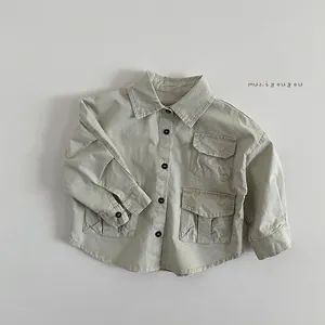 Détail d'une chemise cargo vert clair pour enfant avec trois poches et boutons foncés
