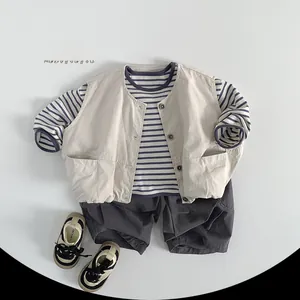 Flat lay of kids striped shirt, beige multi-pocket vest and grey shorts outfit set