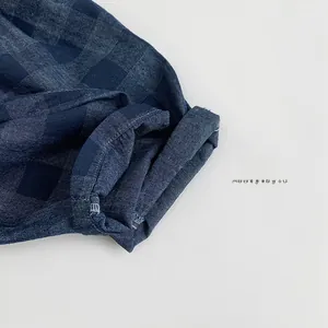 Vue détaillée du tissu en coton à carreaux bleu foncé avec couture d'ourlet soignée