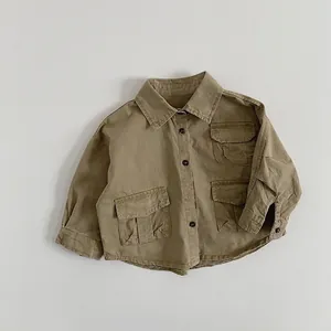 Détail de la veste utilitaire kaki avec trois poches et des boutons foncés