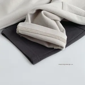 Detailed close-up of knit fabric texture and high-quality stitching in beige and dark gray