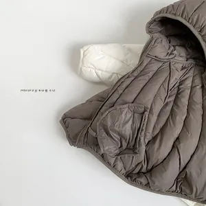 Detail of cocoa brown quilted jacket showing hooded edge and inner pocket texture