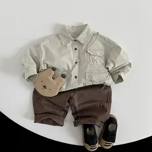 Tenue rétro pour enfants avec chemise vert sauge et pantalon en coton marron et petit sac