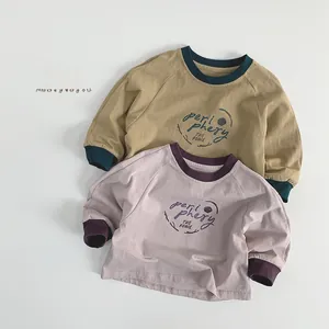 Détail de t-shirts enfants à manches longues avec col côtelé et design raglan
