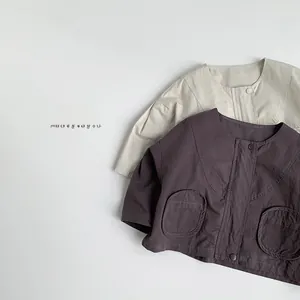 Flat lay of cotton linen kids jackets with round neck and large pockets in cream and purple