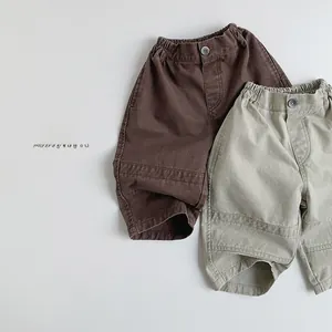 Detail view of retro cotton canvas kids pants in dark brown and light khaki colors