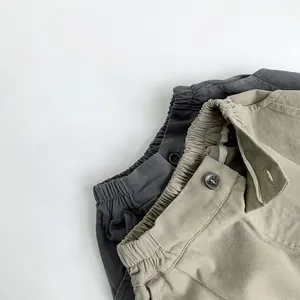 Détail du pantalon en coton pour enfant avec taille élastique et bouton décoratif