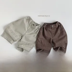 Detail of khaki and dark brown kids cotton shorts with elastic waist and stitching