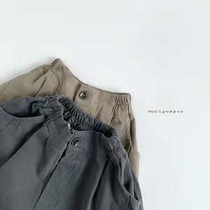 Détails de la taille élastique et des boutons sur le pantalon large enfant gris et kaki