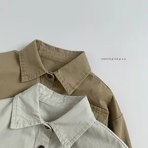 Détail des cols pointus classiques et texture du tissu en coton sur chemises enfants